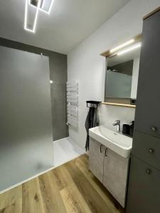 ein Badezimmer mit einem weißen Waschbecken und einem Spiegel in der Unterkunft Wolfgangsee Seeblickplatzl 119 in Strobl