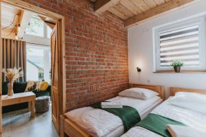 Un dormitorio con dos camas y una pared de ladrillo. en Nowe Domki Jeleni Szlak, en Ustrzyki Dolne