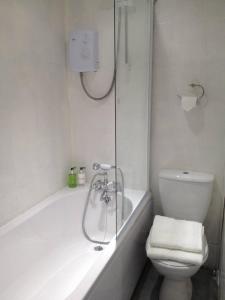 une salle de bain blanche avec une baignoire et des toilettes dans l'établissement 3 Bedroom Cottage minutes walk from town, harbour & Beaches., à St Ives