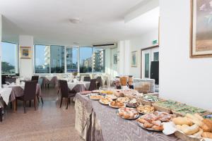a buffet of food on tables in a restaurant at Hotel Asiago Beach in Lido di Savio