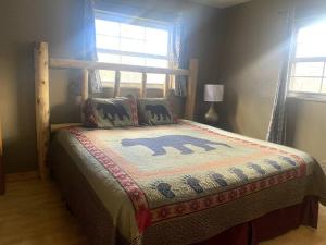 Un dormitorio con una cama con una manta. en Cabin in Gatlingburg L, en Gatlinburg