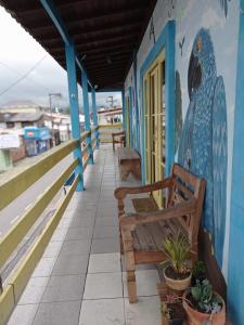 un bâtiment avec bancs et peinture sur le mur dans l'établissement Girassol Hostel by Katita, à Parati