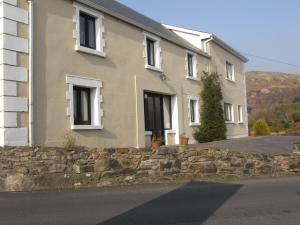 a house with a stone wall in front of a building at Mellottes Self Catering in Cornamona