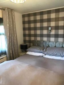 a bedroom with a large bed and a checkered wall at No 1 The Glen in Port Seton