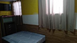 a small bedroom with a bed and a window at Quitinete Expominas Suite Ar in Belo Horizonte