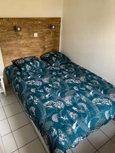 un letto con piumone blu in una camera da letto di Appartement T2 à Port-Bourgenay Résidence île au pré a Talmont