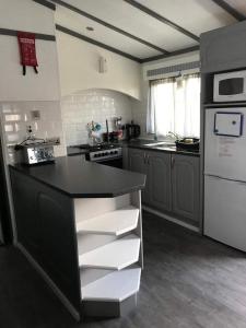 a kitchen with a black counter and a white appliance at No 1 The Glen in Port Seton