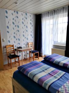 1 dormitorio con 2 camas, mesa y sillas en Ferienwohnungen Hochgrebe, en Kleinern