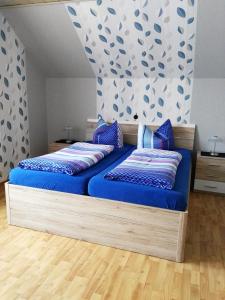 1 dormitorio con 1 cama con sábanas azules y almohadas azules en Ferienwohnungen Hochgrebe, en Kleinern