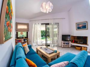 ein Wohnzimmer mit einem blauen Sofa und einem Tisch in der Unterkunft Sani Villa Lili 7 in Sani Beach