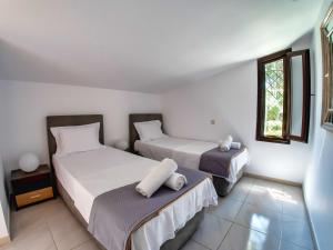 ein Schlafzimmer mit zwei Betten und einem Fenster in der Unterkunft Sani Villa Lili 7 in Sani Beach