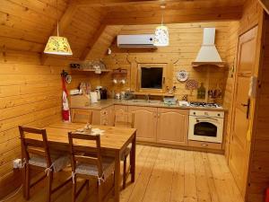 a wooden kitchen with a table and chairs in a cabin at ZŁOTEK in Złoty Stok