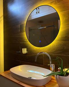 La salle de bains est pourvue d'un lavabo et d'un miroir. dans l'établissement Lovely Loft 1-Bedroom in the heart of Tirana, à Tirana