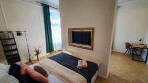 1 dormitorio con 1 cama y TV en la pared en SMARAGD Apartman, en Győr