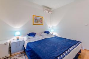 a bedroom with a blue bed with two blue pillows at Guesthouse Rooms Split in Split