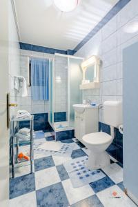 a blue and white bathroom with a toilet and a shower at Guesthouse Rooms Split in Split