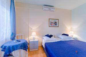 a bedroom with two beds and a blue blanket at Guesthouse Rooms Split in Split