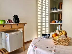 uma cozinha com uma mesa e uma cesta de frutas em B&B Curva della Palma em San Marino