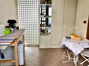 a kitchen with a table and a chair with a basket of fruit at B&B Curva della Palma in San Marino