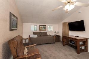 a bedroom with a bed and a flat screen tv at Sleepy Hollow on the River, 3 Bedrooms, Sleeps 8, Hot Tub, Foosball in Ruidoso