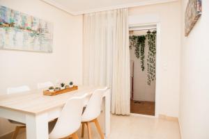 een witte eetkamer met een witte tafel en witte stoelen bij DUPLEX LOFT en la PLAYA in Santa Pola