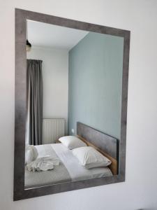 a mirror reflecting a bed in a bedroom at Chriselia House in Nea Roda +7 photos