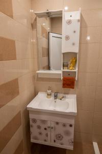 uma casa de banho com um lavatório branco e um espelho. em Your place em Plovdiv