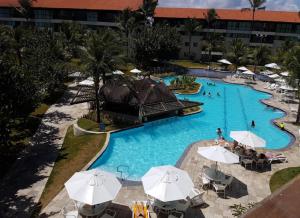 - une vue sur la piscine d'un complexe dans l'établissement Suíte na beira-mar do Resort Marulhos Muro Alto Porto Galinhas, à Porto de Galinhas