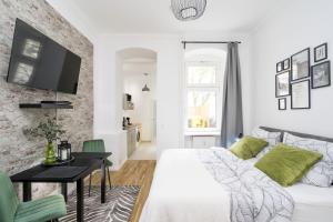 a bedroom with a bed and a table and a tv at The Koburger II - central budget studio with extra high bed, Ideal for families & kids or couples in Berlin
