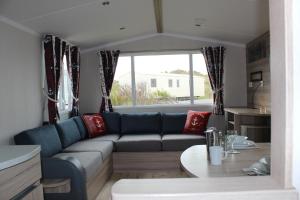 a living room with a couch and a table at Perran Sands Perranporth in Perranporth