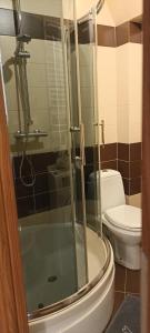 uma casa de banho com um WC e uma cabina de duche em vidro. em Apartamenty Gryfice Centrum - Nadrzeczna 2 em Gryfice