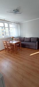 uma sala de estar com uma mesa e um sofá em Apartamenty Gryfice Centrum - Nadrzeczna 2 em Gryfice