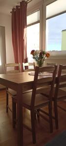 uma mesa e cadeiras de madeira com um vaso de flores em Apartamenty Gryfice Centrum - Nadrzeczna 2 em Gryfice