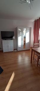 uma sala de estar vazia com uma televisão e uma mesa em Apartamenty Gryfice Centrum - Nadrzeczna 2 em Gryfice