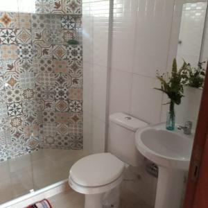 a bathroom with a toilet and a sink at Casa Verde da Floresta da Gávea in Visconde De Maua