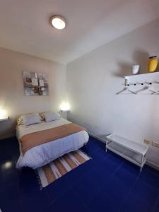 a bedroom with a bed and a blue floor at Casita Miramar in El Paso