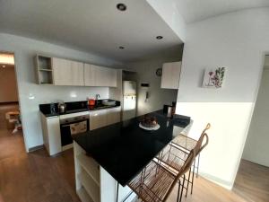 a kitchen with a black counter top in a room at DEPTO NUEVO CON PILETA EN NUÑEZ in Buenos Aires