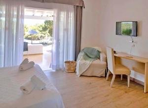 a bedroom with a desk and a bed and a desk and chair at Roquetes Bungalows Premium - Formentera Break in Es Pujols