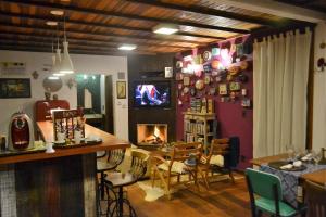 a living room with a fireplace and a table and chairs at Pousada Encanto da Bocaina - Serra da Bocaina in São José do Barreiro