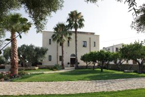 a building with palm trees in front of it at Casal Sikelio in Cassibile