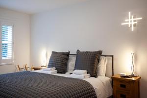 um quarto com uma cama com almofadas e uma cruz na parede em Keswick Ground floor apartment with parking em Keswick