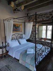 a bedroom with a metal bed with white sheets at Bayiri Petit Pension in Litochoro