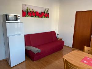 a living room with a red couch and a refrigerator at Karlovický dvůr 251 in Karlovice
