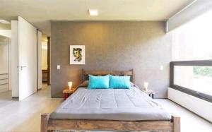 ein Schlafzimmer mit einem großen Bett mit blauen Kissen in der Unterkunft House in Chacras de Coria Ruta del Vino in Chacras de Coria + 27 Fotos