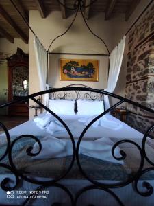 a bedroom with a bed with a wrought iron bed frame at Bayiri Petit Pension in Litochoro