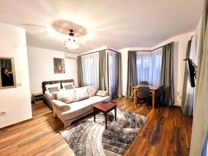a living room with a couch and a table at Pirin Golf Hotel Private Studios - Sani, Bansko in Razlog +119 photos
