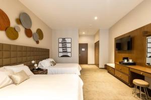 a hotel room with two beds and a television at Antigua Hotel Boutique in Mexico City
