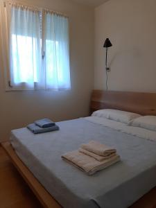 ein Schlafzimmer mit einem Bett, auf dem zwei Handtücher liegen in der Unterkunft Nuova casa al lago con piscina in Desenzano del Garda