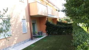 ein Haus mit einem grünen Hof neben einem Gebäude in der Unterkunft Nuova casa al lago con piscina in Desenzano del Garda