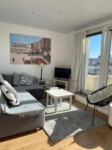 een woonkamer met een bank en een tafel bij Appartement Fr Gilkens Ostende in Oostende